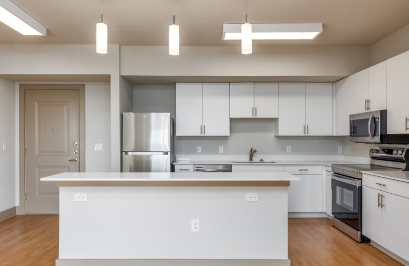 A modern kitchen with white cabinets and stainless steel appliances.